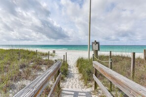 A wooden boardwalk leading to a beach with a signpost. - Walk to the beach at Jo Jo's Beach Getaway! (Panama City Beach)