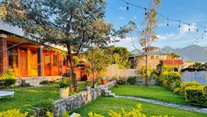 A residential area with a house featuring a brick facade, a stone pathway, and a well-maintained lawn. - Casa del Abuelo (San Pedro La Laguna)