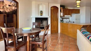 A compact living space with a dining area, kitchen, and a sofa. - Puerto Nuevo Villa Las Conchas 2BR 2 BA with pool (Centro Turístico El Pescador)