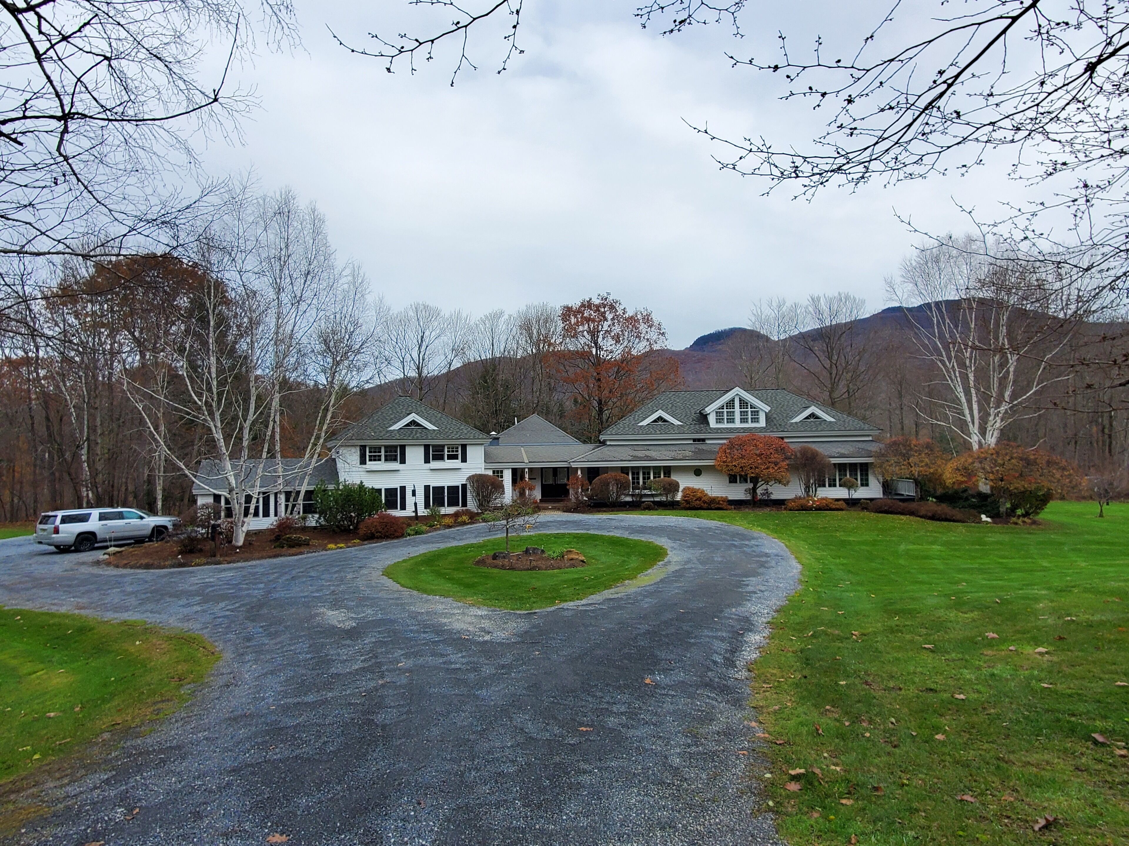A two-story house with a driveway leading to a front porch.