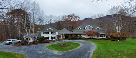 A two-story house with a driveway leading to a front porch.