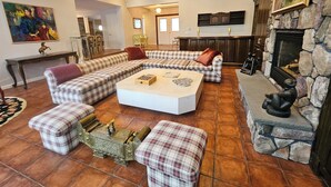 Amplia sala de estar con un sofá modular grande, una mesa de centro y una chimenea.
