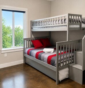 A bunk bed room with a window, a white wall, and a brown floor. - Cozy Home by Tanglewood | A Quiet Comfortable Stay (Pottsboro)