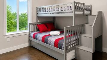A bunk bed with a window view, a small desk, and a chair.