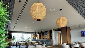 Un área de estar moderna con mesa de billar, asientos cómodos y una zona de bar.