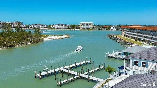 A marina with docked boats, a clear blue sky, and buildings in the background. - Dolphin Paradise- Peaceful 1-bedroom condo in historic Old Marco Island (Marco Island)