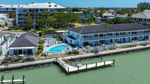 A coastal hotel with a pool, waterfront views, and a dock. - Dolphin Paradise- Peaceful 1-bedroom condo in historic Old Marco Island (Marco Island)