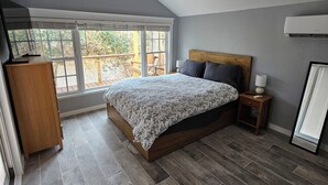 Un dormitorio con cama, mesita de noche, escritorio y ventilador de techo.