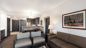 A modern living room with a sofa, a bench, and a dining area with a chandelier. - Park City, Ski-in, Ski-out, 2-bed 2 bath, Sleeps 8 (Park City)