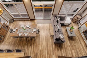 A spacious loft with a dining area, seating, and a view of the deck. - Spa, Pool table & River | Hauteur du Saint-Maurice (Grandes-Piles)