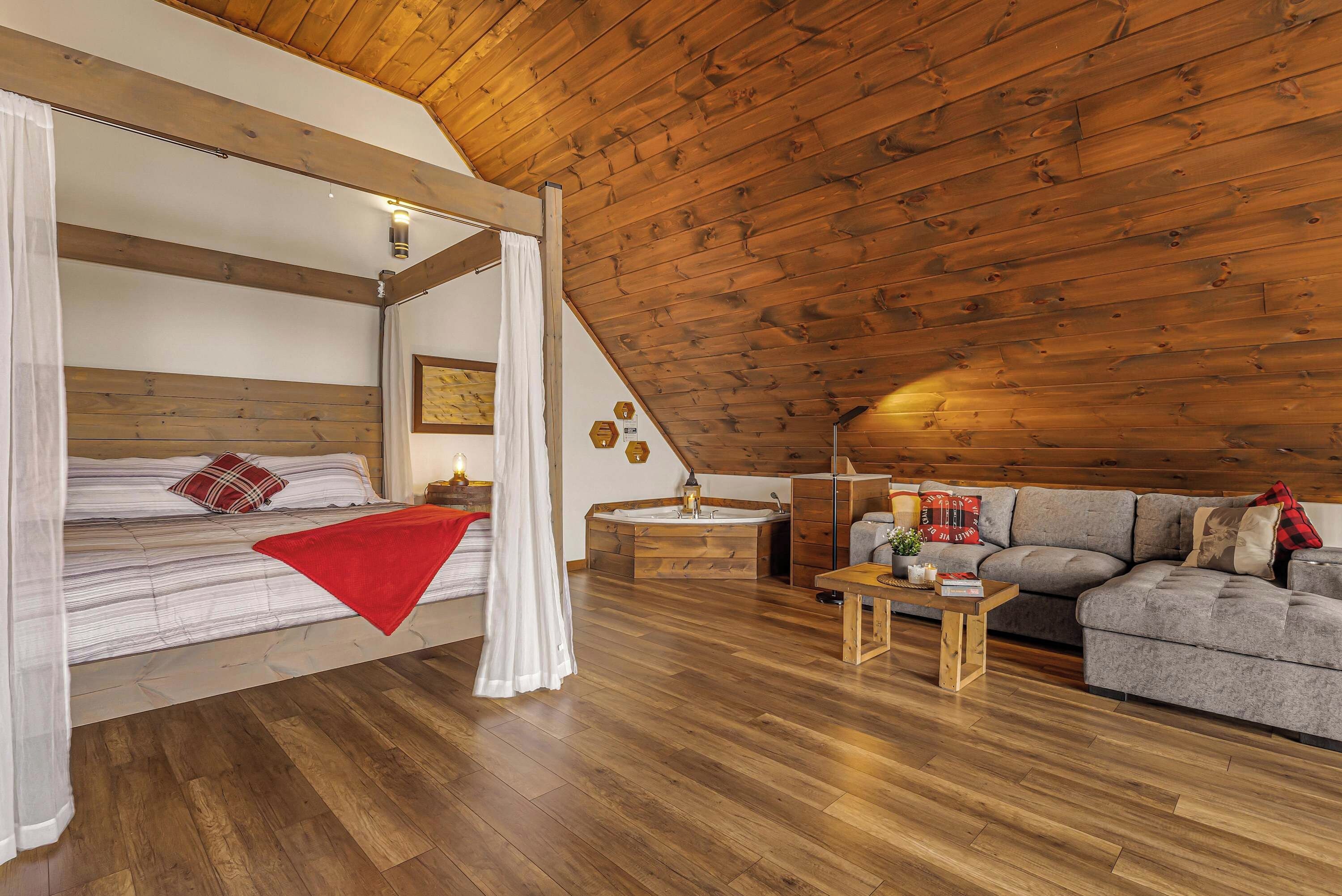 Een gezellige slaapkamer met een bed, nachtkastje en een slaapbank.