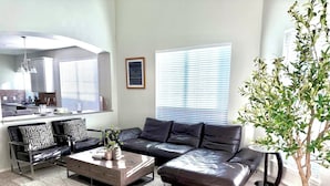 Un salon moderne avec un canapé en cuir, une table basse et une plante en pot.