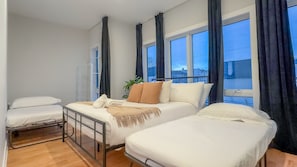 A bedroom with two beds, a window with curtains, and a view of the outside. - Pristine Pad, Sleep 12, Free parking, 3BRs, 20%OFF (East Newark)