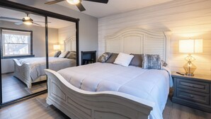 A bedroom with a large bed, a ceiling fan, a nightstand with a lamp, and a mirror on the wall. - 3-bedroom house in peaceful Creve Coeur private fenced yard minutes from Peoria  (Creve Coeur)