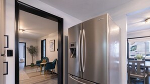 A modern kitchen with a stainless steel refrigerator, wooden flooring, and a dining area with a table and chairs. - 3-bedroom house in peaceful Creve Coeur private fenced yard minutes from Peoria  (Creve Coeur)