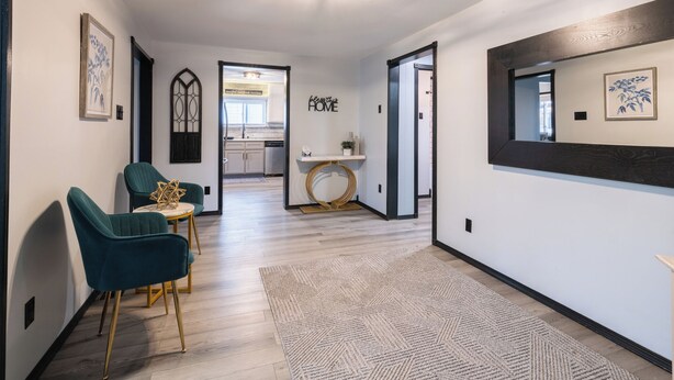 A hallway with teal chairs, a wooden floor, and a rug. - 3-bedroom house in peaceful Creve Coeur private fenced yard minutes from Peoria  (Creve Coeur)