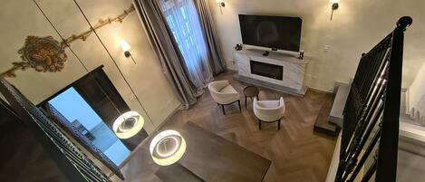 Una sala de estar moderna con una televisión de pantalla plana, dos sofás, una mesa de centro y una chimenea.
