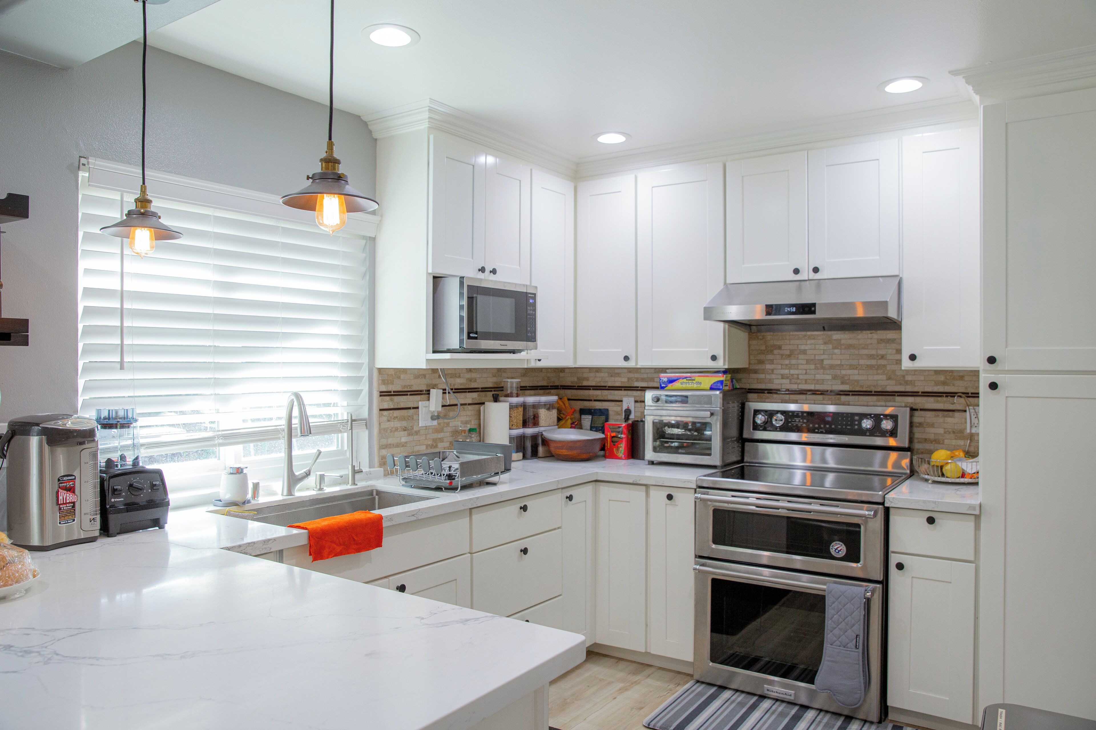 Una cocina moderna con armarios blancos, electrodomésticos de acero inoxidable y una isla grande.