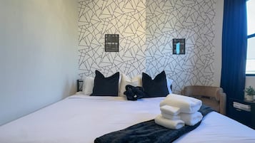 Tabla de planchar con plancha, internet y ropa de cama