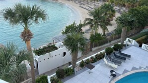 A coastal resort with a pool area, beach, and palm trees. - 2-bedroom apartment in Blue Bay Resort (Willemstad)