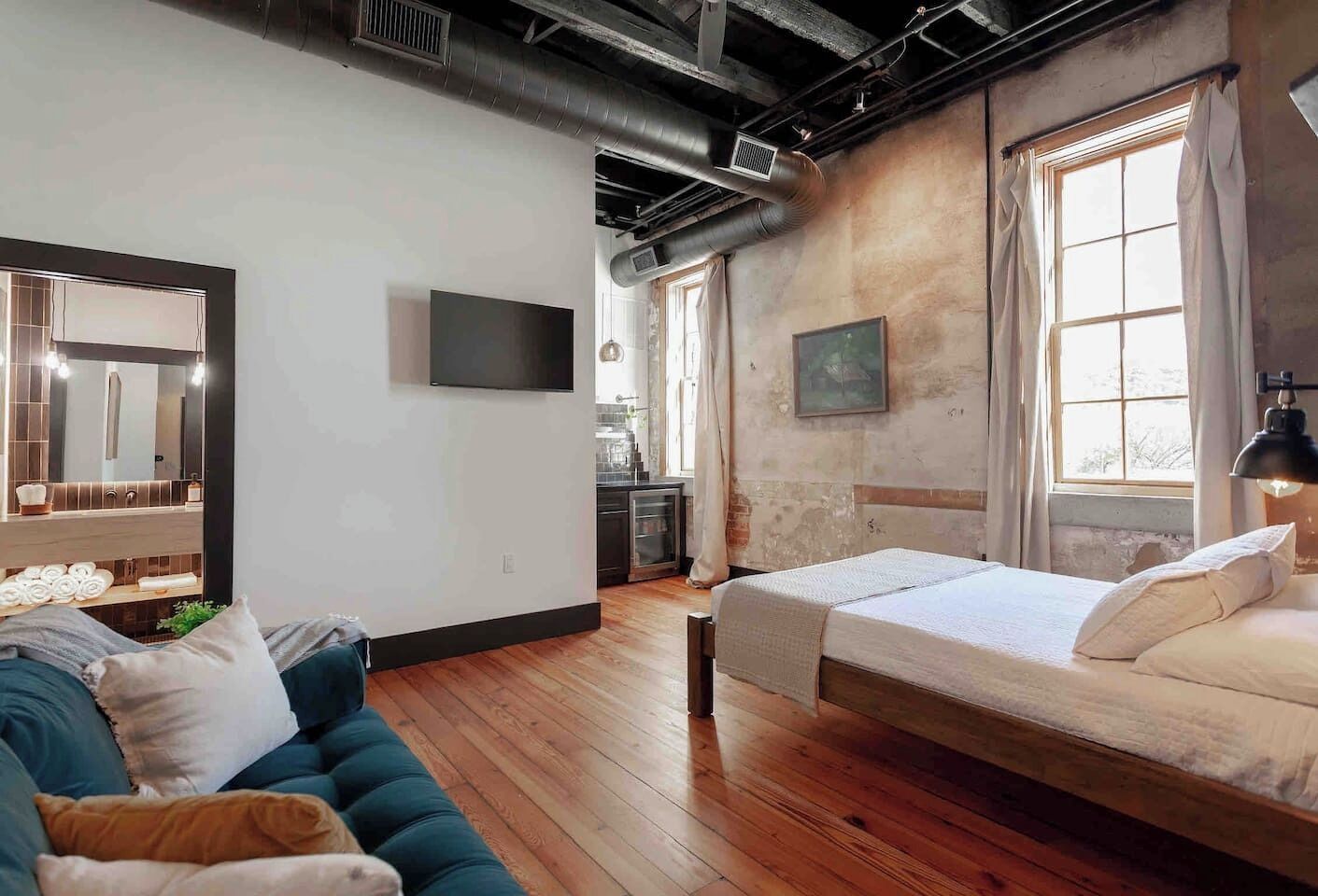 Une chambre moderne équipée d’un lit, d’un canapé, d’une télévision et d’un coin cuisine.