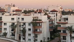 Un quartier résidentiel composé d’immeubles d’appartements modernes, dotés de balcons et d’une allée incurvée.