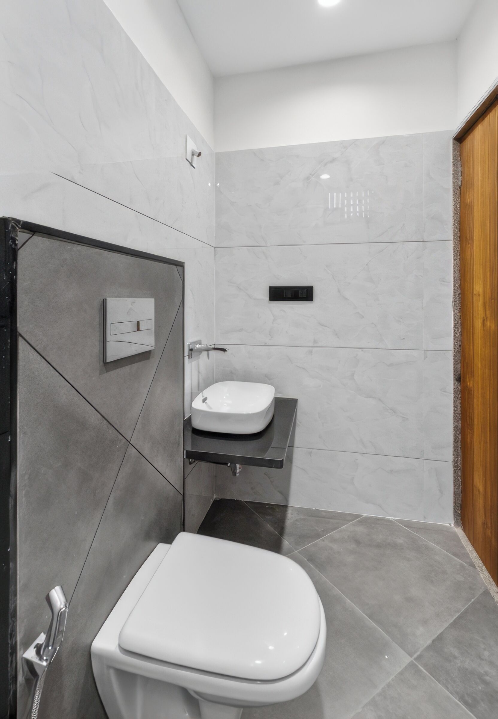 Une salle de bain moderne avec des toilettes blanches, un meuble-lavabo avec un miroir et un espace douche.