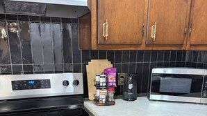 A kitchen with a Whirlpool stove, a microwave, and wooden cabinets. - 12 miles to Ponca, Close to Kaw Lake & Casinos, Dog Friendly (Newkirk)