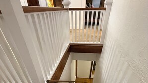 A staircase with white railings and wooden steps leading to a second-floor landing. - 12 miles to Ponca, Close to Kaw Lake & Casinos, Dog Friendly (Newkirk)