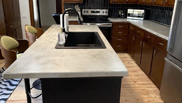 A modern kitchen with wooden cabinets, a central island, stainless steel appliances, and a ceiling fan. - 12 miles to Ponca, Close to Kaw Lake & Casinos, Dog Friendly (Newkirk)