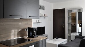 A modern kitchen with dark cabinets, a wooden countertop, and a coffee machine. - Elena House - Mareri apartments (Villa Faraldi)