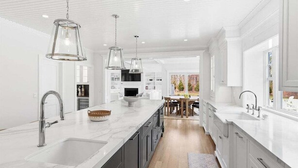 A modern kitchen with white cabinetry, a marble countertop, and pendant lighting. - Olivia's Oasis: 006-HL - Stunning New Construction with Heated Pool & Hot Tub in Harwich (Harwich)
