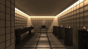 Un bagno moderno con piastrelle sulle pareti, un lavandino al centro e un vaso decorativo.