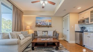 A living room with a sofa, coffee table, and a painting on the wall. - “Sun-kissed” condo , Fantastic location in Baytown Wharf,  Sandestin. (Miramar Beach)