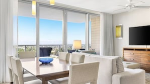 Een moderne hotelkamer met balkon, een zithoek en een televisie.