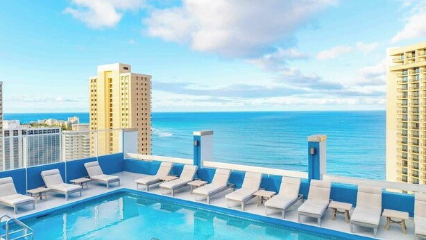 A rooftop pool with lounge chairs, a butterfly design on the pool, and a view of the ocean. - Oceanview Remodeled Studio in the heart of Waikiki, walk to shops, food, & beach (Honolulu)