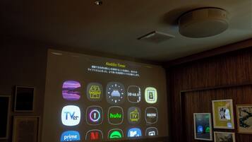 Une projection des logos de différents services de diffusion en continu sur un mur, notamment TVer, Hulu et Netflix.