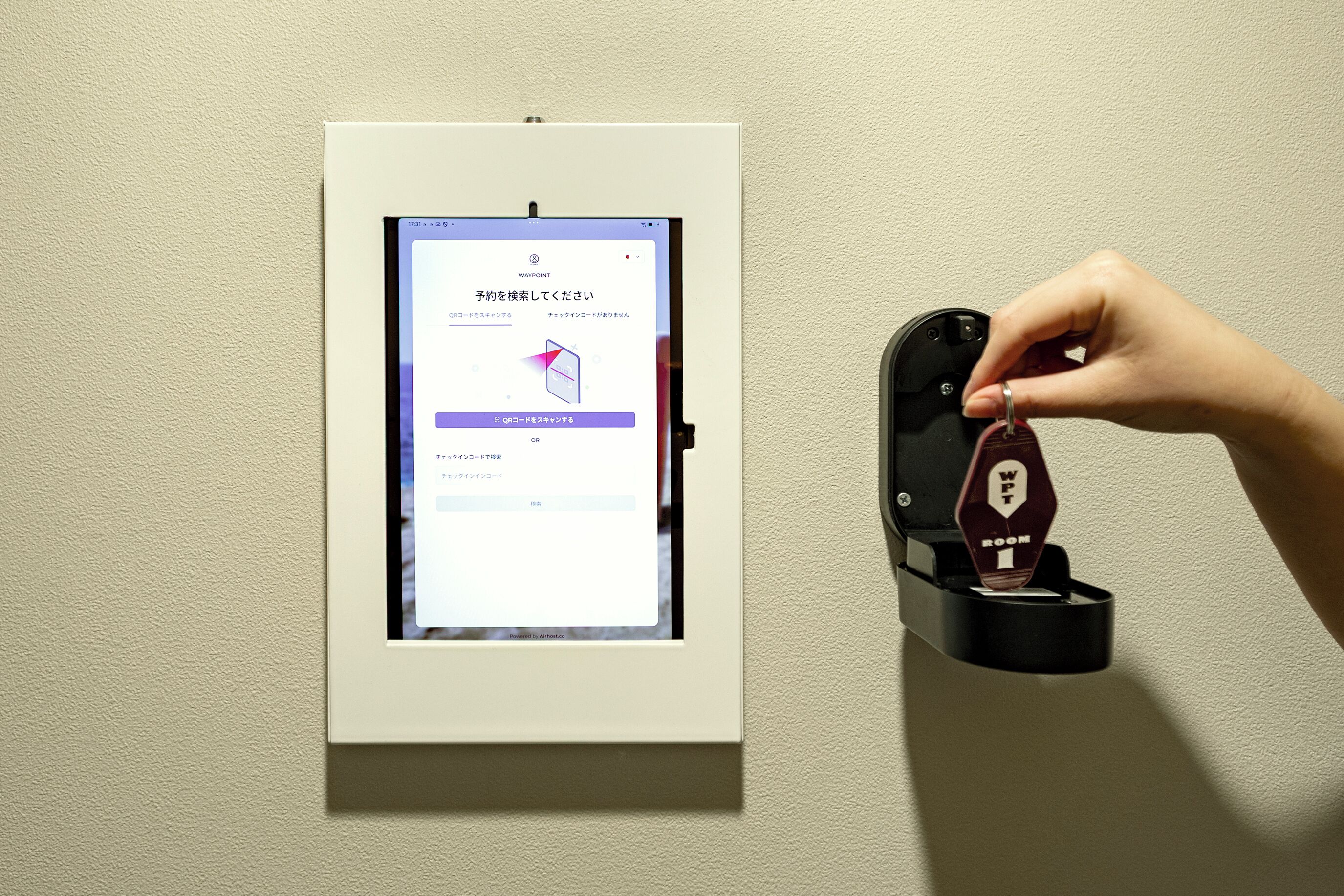 Un lector de llave digital instalado en una pared, con una tableta mostrando una interfaz de usuario.