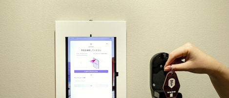 Un lector de llave digital instalado en una pared, con una tableta mostrando una interfaz de usuario.