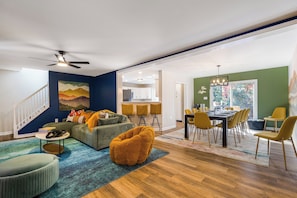 Una sala moderna con un sofá, un reposapiés y un comedor con sillas y una mesa.