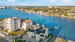 A waterfront property with a multi-story building, a dock, and a marina. - 3BR Water View Condo | Boat Access+Great Location (Treasure Island)