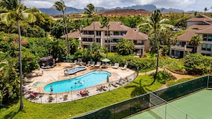 A resort with a swimming pool, multiple buildings, and lush greenery. - Luxury Ocean-View 2BR Condo | Walk to Poipu Beach | Sleeps 6 (Koloa)