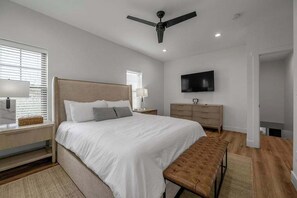 A bedroom with a bed, a bench, a TV, a ceiling fan, and a dresser. - Pool | Sleeps 18 | Hot Tub |Firepit | Playset | (Williamstown)