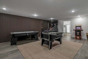 A room with a pool table, foosball table, and a video game machine. - Pool | Sleeps 18 | Hot Tub |Firepit | Playset | (Williamstown)