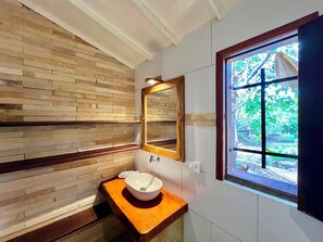 A bathroom with a wooden wall, a wooden countertop, a white sink, and a window with a view of greenery. - Pousada e Restaurante do Paulo (Jijoca de Jericoacoara)