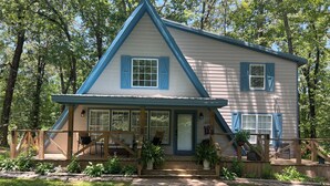A two-story house with a porch, blue shutters, and a number 279 sign.