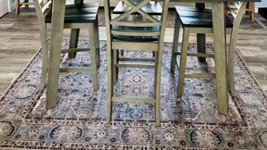 A dining area with a table, chairs, and a decorative birdcage centerpiece.