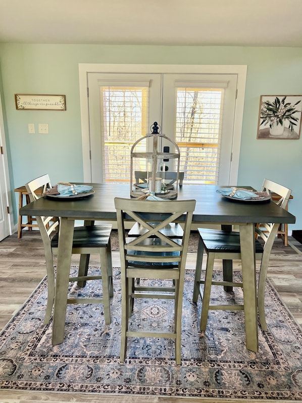 Un comedor con una mesa, sillas y una jaula decorativa como centro de mesa.