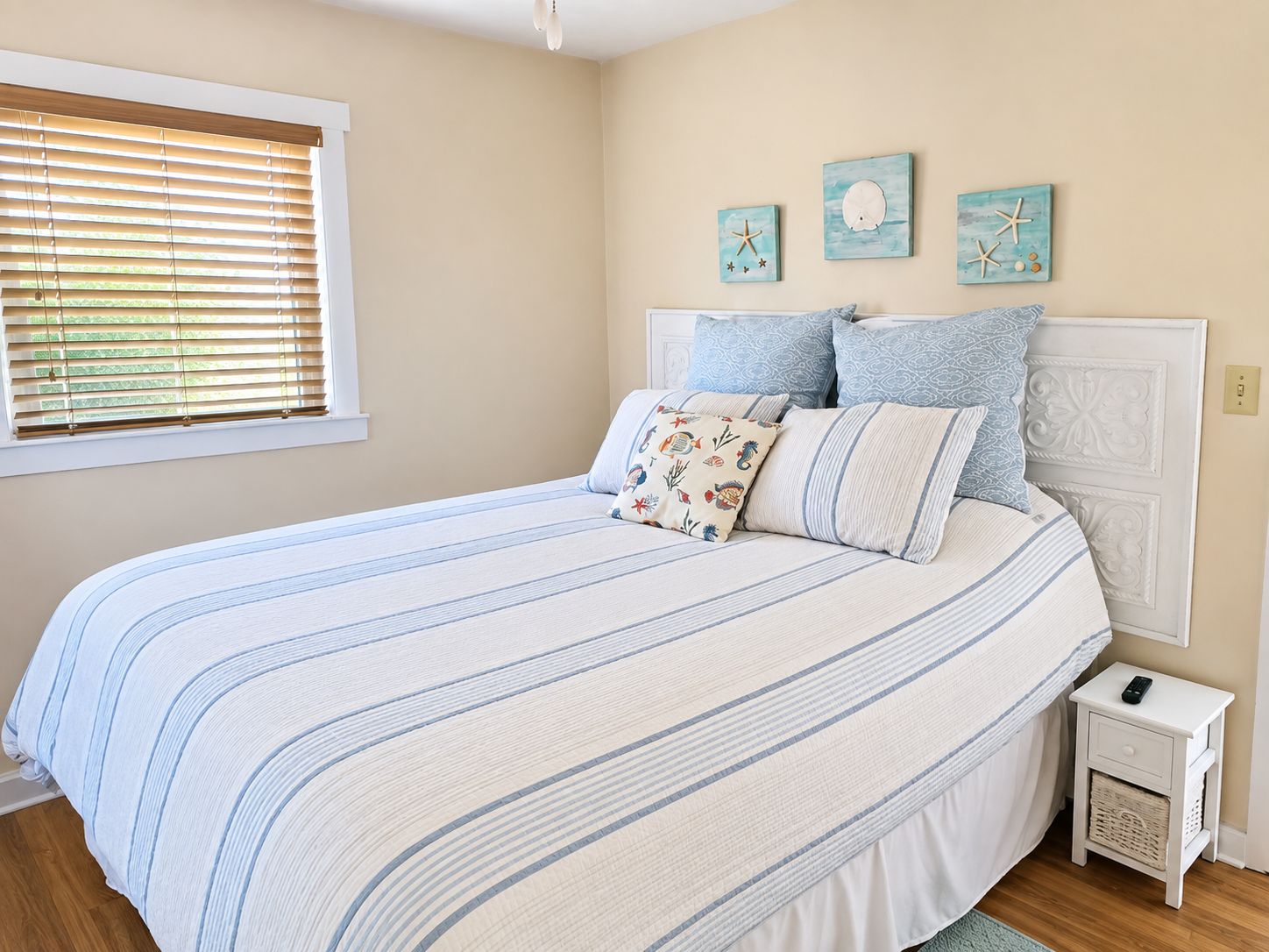 Un dormitorio con cama, mesita de noche y decoración en la pared.