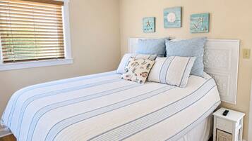 Un dormitorio con cama, mesita de noche y decoración en la pared.